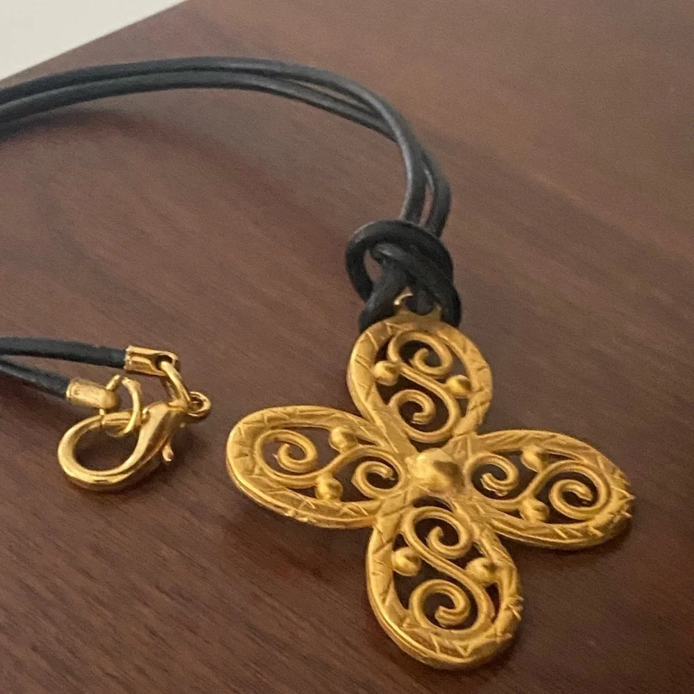 𝅺gold tone choker style necklace on leather cord